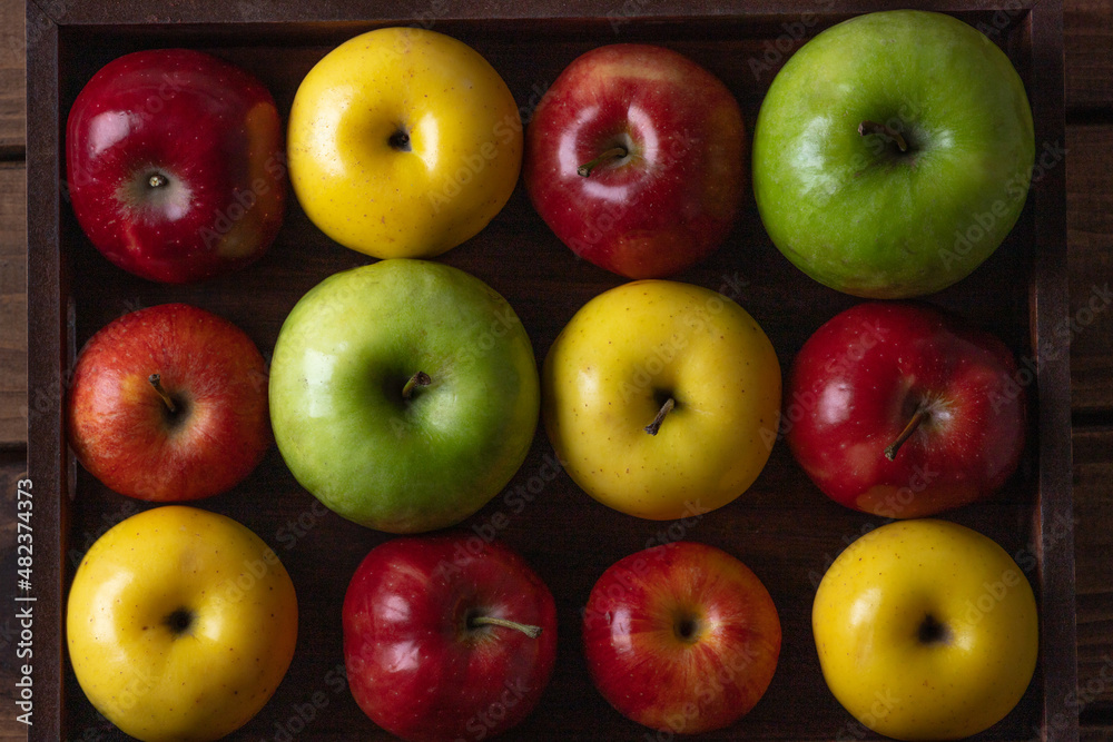 Colorful apples. Red, yellow and green apples on a wooden tray Colorful apples. Red, yellow and green apples on a wooden tray
