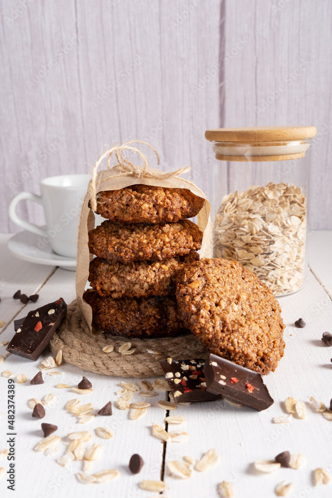 Fototapeta premium Homemade oatmeal cookies with chocolate and nuts tied with jute thread on baking paper