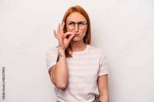 Young caucasian woman isolated on white background with fingers on lips keeping a secret.