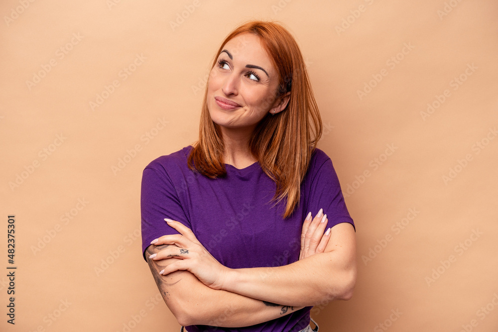Obraz premium Young caucasian woman isolated on beige background dreaming of achieving goals and purposes
