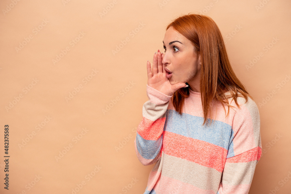 Young caucasian woman isolated on beige background is saying a secret hot braking news and looking aside Young caucasian woman isolated on beige background is saying a secret hot braking news and looking aside