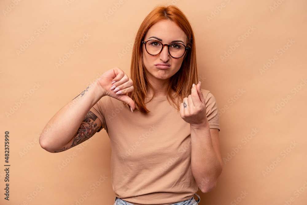 Fototapeta premium Young caucasian woman isolated on beige background showing that she has no money.