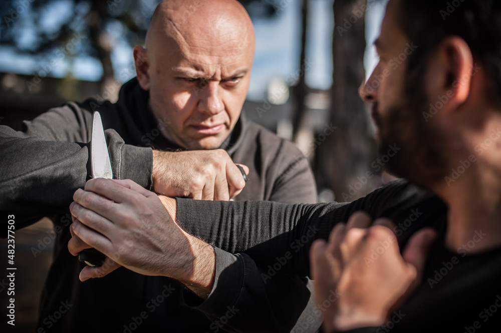 Knife vs knife fight. Kapap instructors demonstrates sombrada drill training