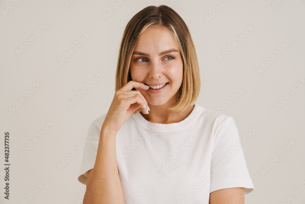 Young blonde woman in t-shirt laughing while looking aside Young blonde woman in t-shirt laughing while looking aside