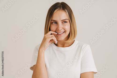 Young blonde woman in t-shirt laughing while looking aside