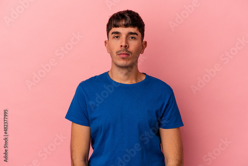 Young mixed race man isolated on pink background sad, serious face, feeling miserable and displeased.