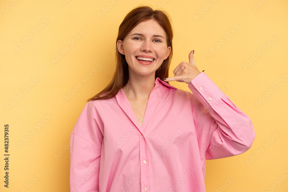 Young English woman isolated on yellow background showing a mobile phone call gesture with fingers. Young English woman isolated on yellow background showing a mobile phone call gesture with fingers.
