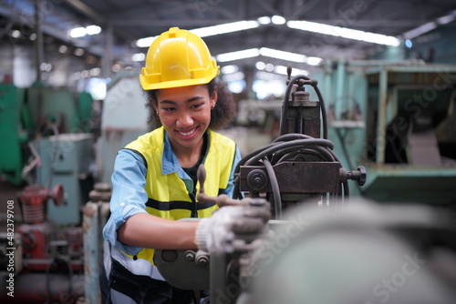 Female apprentice in metal working factory, Portrait of working female industry technical worker or engineer woman working in an industrial manufacturing factory company.