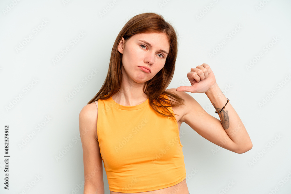 Young English woman isolated on blue background showing a dislike gesture, thumbs down. Disagreement concept. Young English woman isolated on blue background showing a dislike gesture, thumbs down. Disagreement concept.