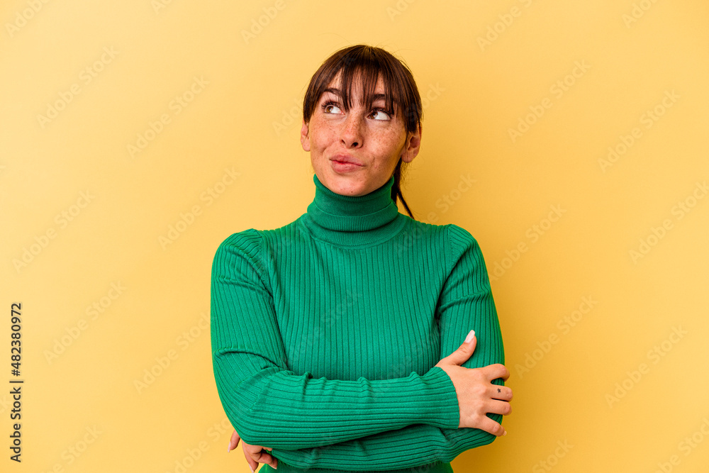 Obraz premium Young Argentinian woman isolated on yellow background dreaming of achieving goals and purposes