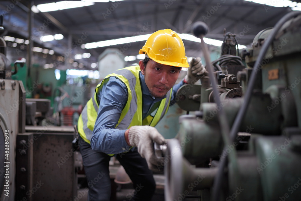 Male engineer metalworker industrial experienced operator technician worker in safety hard helmet working on lathe machine, professional man in industry technology manufacturing factory workshop Male engineer metalworker industrial experienced operator technician worker in safety hard helmet working on lathe machine, professional man in industry technology manufacturing factory workshop