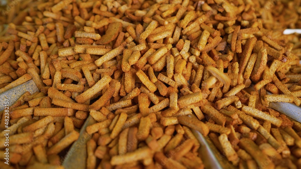 Breadcrumbs production. Dry bread in production. Process of making crackers. Bread crumbs are pouring from the conveyor. Breadcrumbs production. Dry bread in production. Process of making crackers. Bread crumbs are pouring from the conveyor.