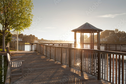 Fotobehang Panoramic view of wooden deck with bench and bower along the river bank