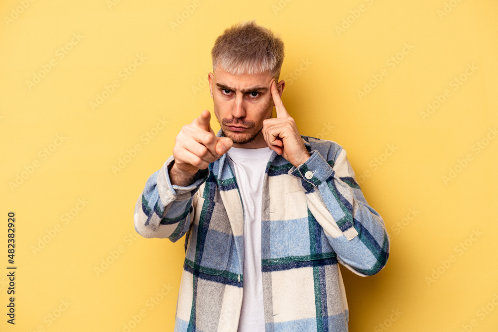 Young caucasian man isolated on yellow background pointing temple with finger, thinking, focused on a task. Young caucasian man isolated on yellow background pointing temple with finger, thinking, focused on a task.