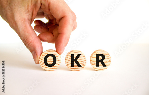 OKR, objectives and key results symbol. Concept words OKR objectives and key results on wooden circles on a beautiful white background. Business OKR objectives and key results concept. Copy space.