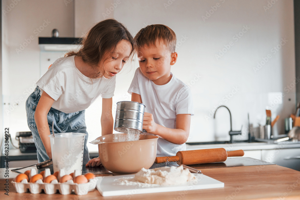 New year anticipation. Little boy and girl preparing Christmas cookies on the kitchen New year anticipation. Little boy and girl preparing Christmas cookies on the kitchen