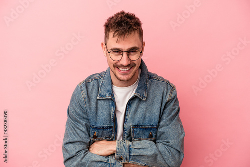 Young caucasian man isolated on pink background laughing and having fun. © Asier