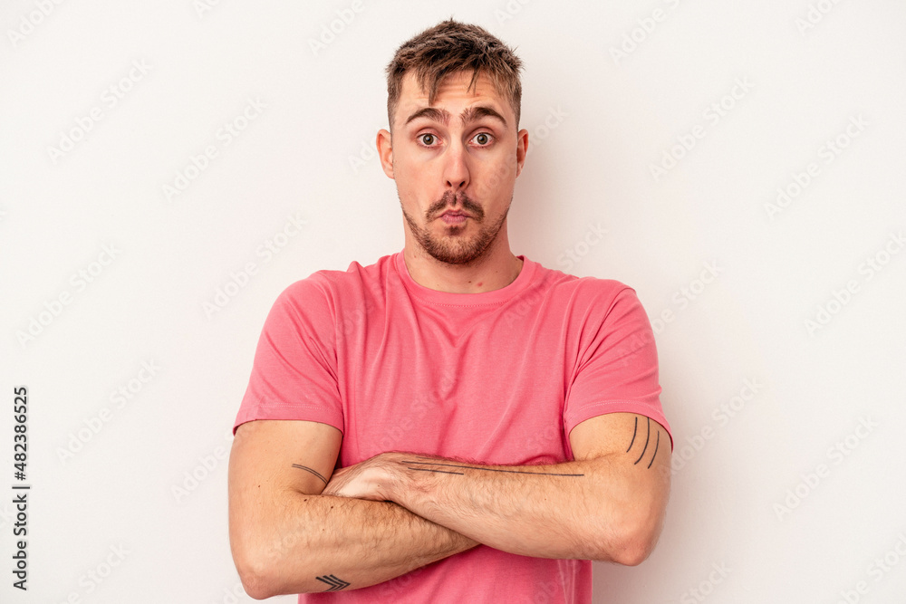Young caucasian man isolated on white background being shocked due to an imminent danger