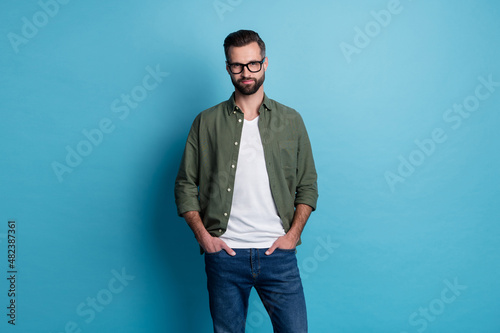 Photo of handsome businessman hold hands pockets wear glasses big company manager isolated on blue color background