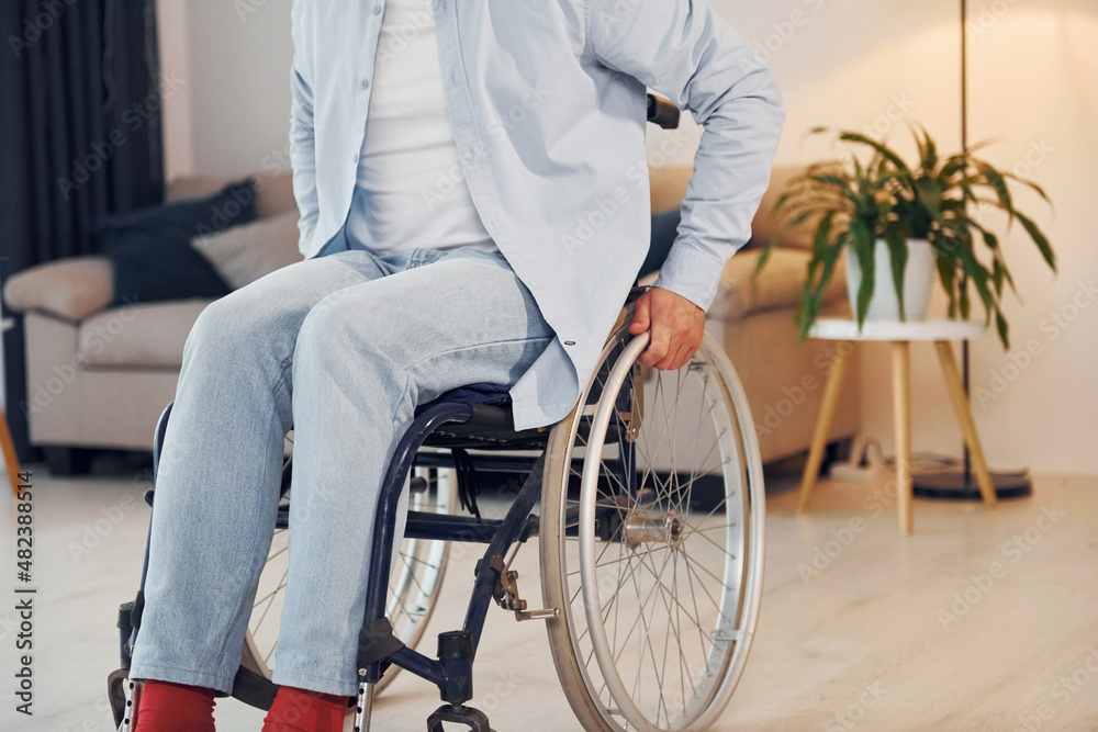 Close up view. Disabled man in wheelchair is at home Close up view. Disabled man in wheelchair is at home
