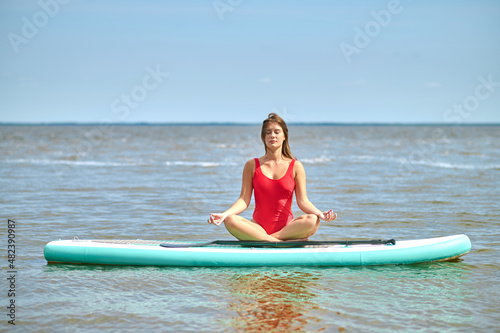 A woman in a red swimming suit kayaking and feeling peaceful photo