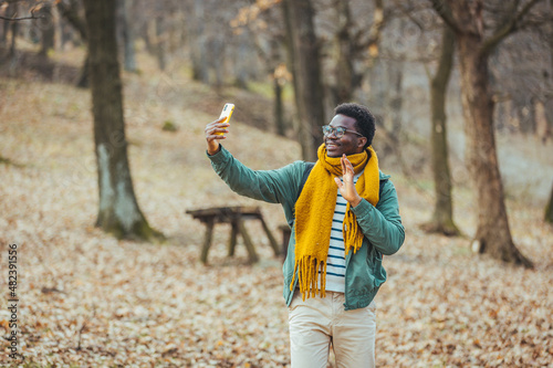 A cheerful African-American enjoys taking selfies. Travel alone  explore wildlife  stay positive. Camping in the woods  time for adventure and the concept of rest