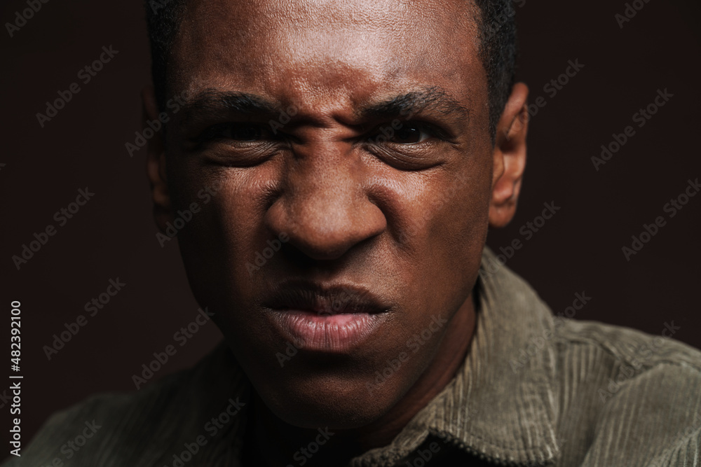 Young black man frowning and looking at camera Young black man frowning and looking at camera