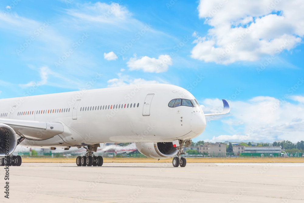 The plane turns onto the apron from the runway against the background of blue sky and clouds. The plane turns onto the apron from the runway against the background of blue sky and clouds.