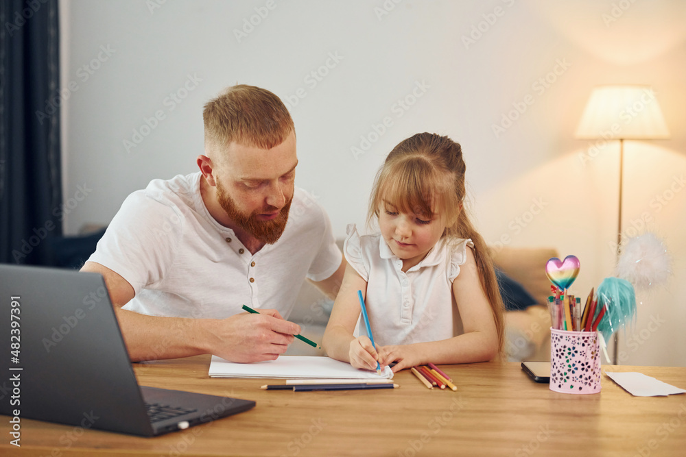 Using laptop. Father with his little daughter is at home together Using laptop. Father with his little daughter is at home together