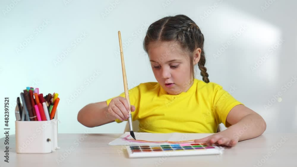 Child girl drawing a rainbow. child artist draws at the table in kindergarten. coronavirus pandemic stay home concept. kid draws a rainbow. indoor school kindergarten drawing lesson Child girl drawing a rainbow. child artist draws at the table in kindergarten. coronavirus pandemic stay home concept. kid draws a rainbow. indoor school kindergarten drawing lesson