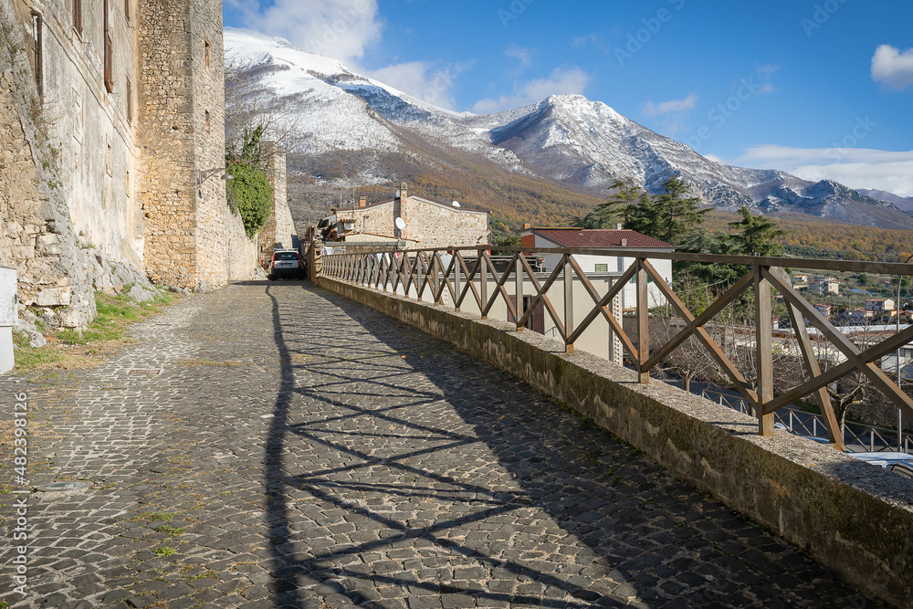 Obraz premium Beautiful landscape with snow-capped mountains and shadow from fence in Vico nel Lazio in province of Fronzinone, Italy