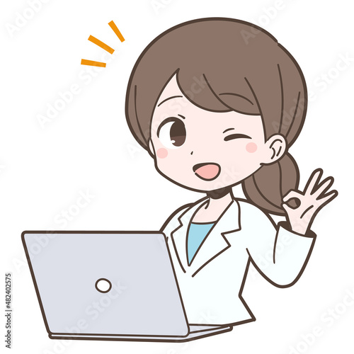 白衣姿でPCの前でOKサインを出す若い女性