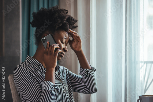 Foto Outraged attractive employee talking on the phone, arguing with a client or cust