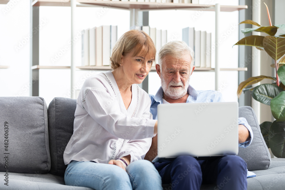 senior couple using laptop computer on sofa senior couple using laptop computer on sofa