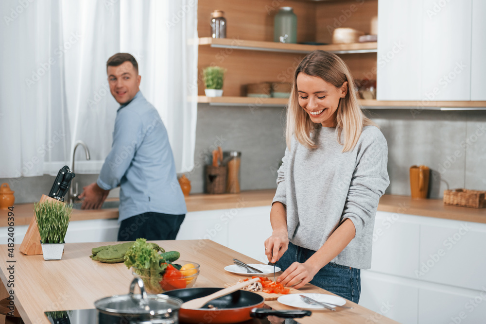 Positive emotions. Couple preparing food at home on the modern kitchen