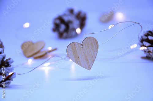 Garland of wooden hearts, cones on a blue background.