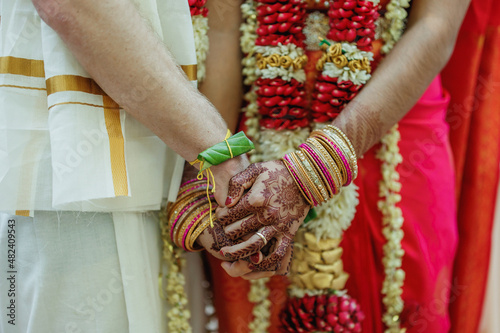 Photography Indian Bride in red dress and Groom in white costume holding hands ritual Closeu
