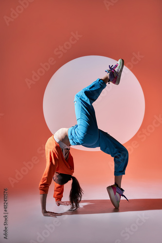 Flexible woman performing wheel pose with raised leg