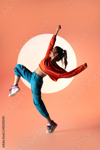 Happy woman dancing with raised hands in studio