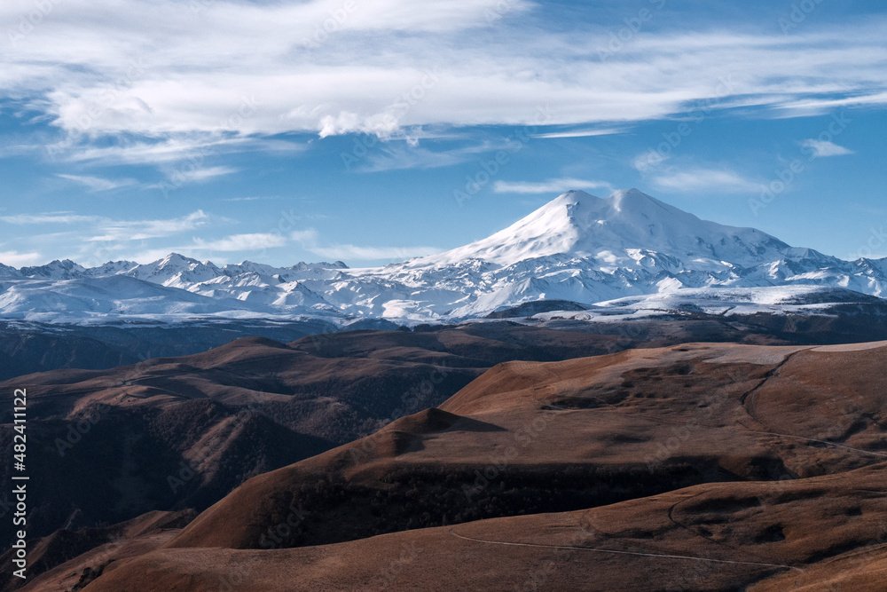 Great nature mountain range. Amazing perspective of  Elbrus with autumn fields, blue sky background.