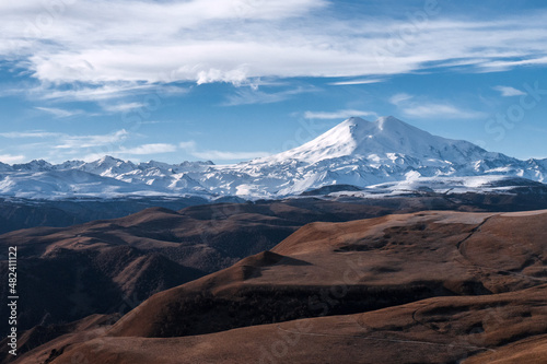 Great nature mountain range. Amazing perspective of Elbrus with autumn fields, blue sky background.