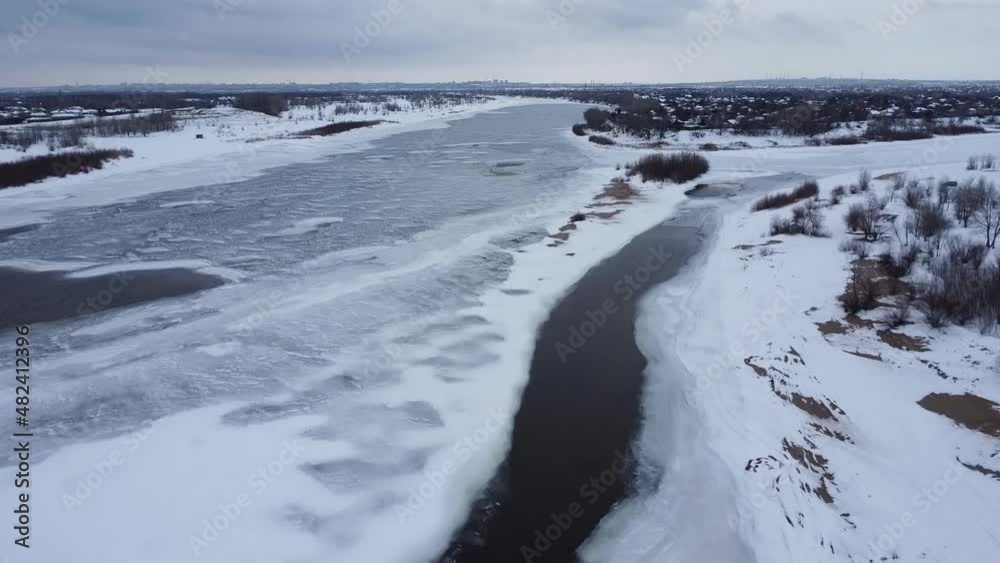 Winter landscape. View of the freezing river. Ice and snow, trees and a city in the distance, Frost. Aerial view Winter landscape. View of the freezing river. Ice and snow, trees and a city in the distance, Frost. Aerial view
