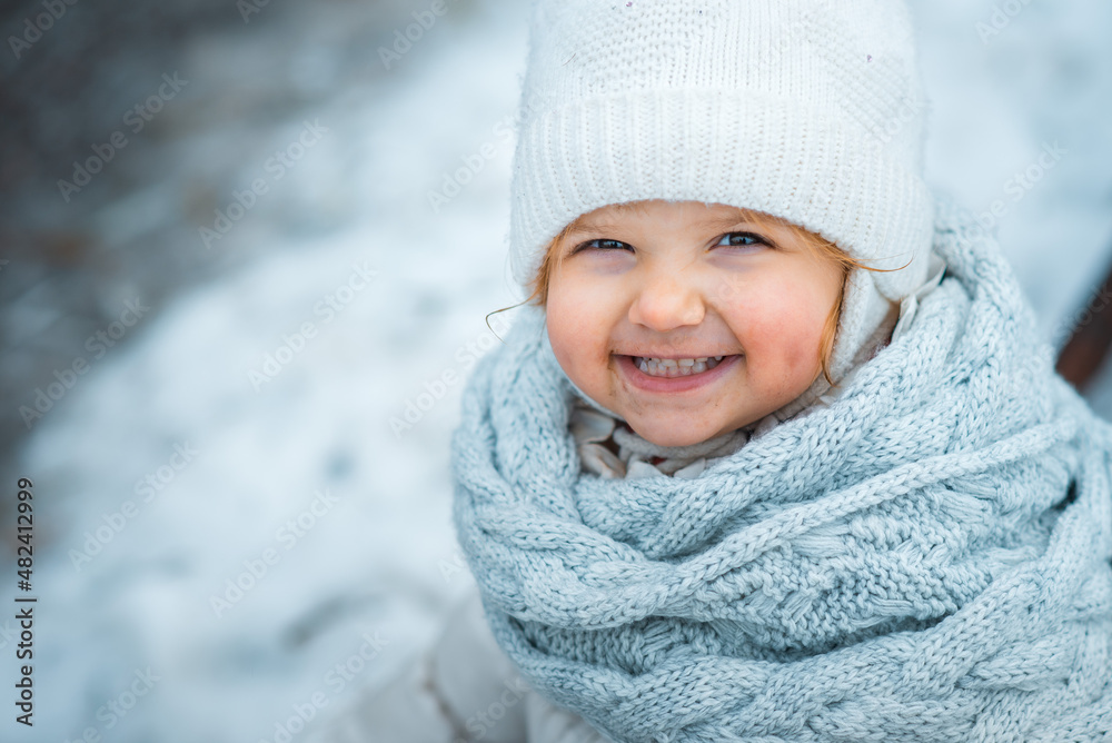 portrait of a little girl in winter, child with dirty face smiling, a kid is dressed in a knitted scarf and a hat with bubo portrait of a little girl in winter, child with dirty face smiling, a kid is dressed in a knitted scarf and a hat with bubo