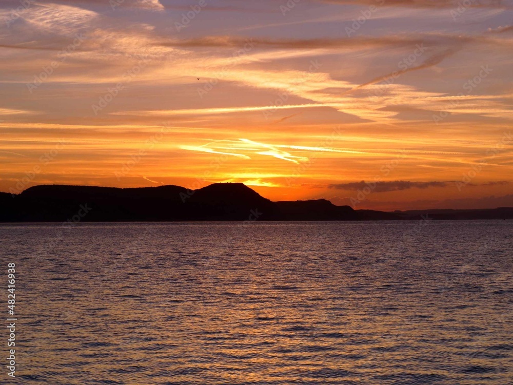 beautiful bright orange sky at sunrise over the sea and cliffs