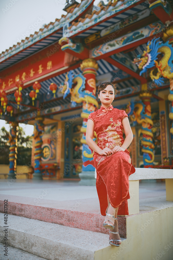 Fototapeta premium Beautiful Asian Chinese Woman Wearing Cheongsam Traditional Red Dress Fashion Posting Chinese Lunar New Year.