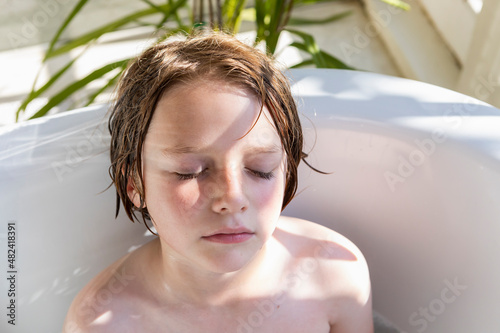 Eight year old boy in a bathtub