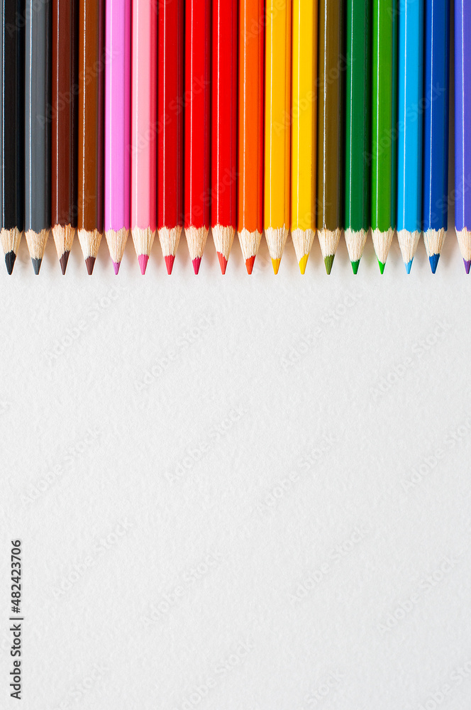 Set of wooden colored pencils- crayons on a white paper. Top view. Set of wooden colored pencils- crayons on a white paper. Top view.