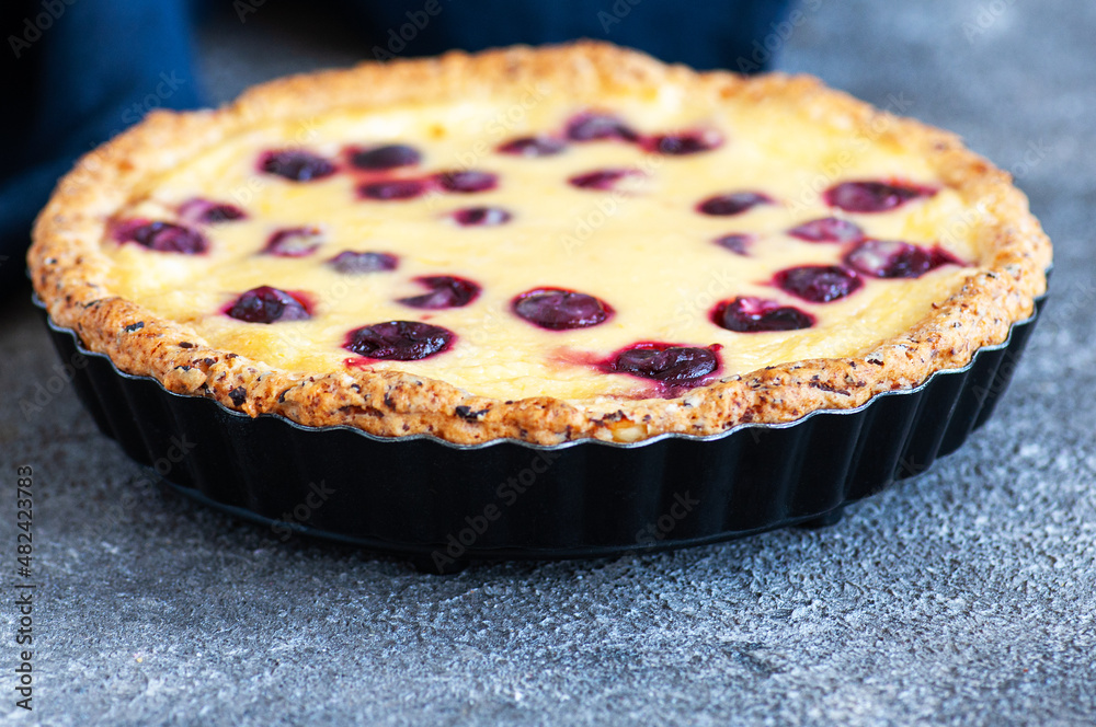 Homemade ricotta cheese pie with cherries on a gray background. Close up. Hearty baking. Homemade ricotta cheese pie with cherries on a gray background. Close up. Hearty baking.