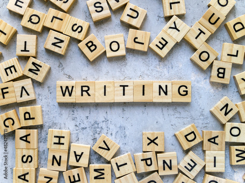 Top view of the word WRITING. Wooden letters add up to words.