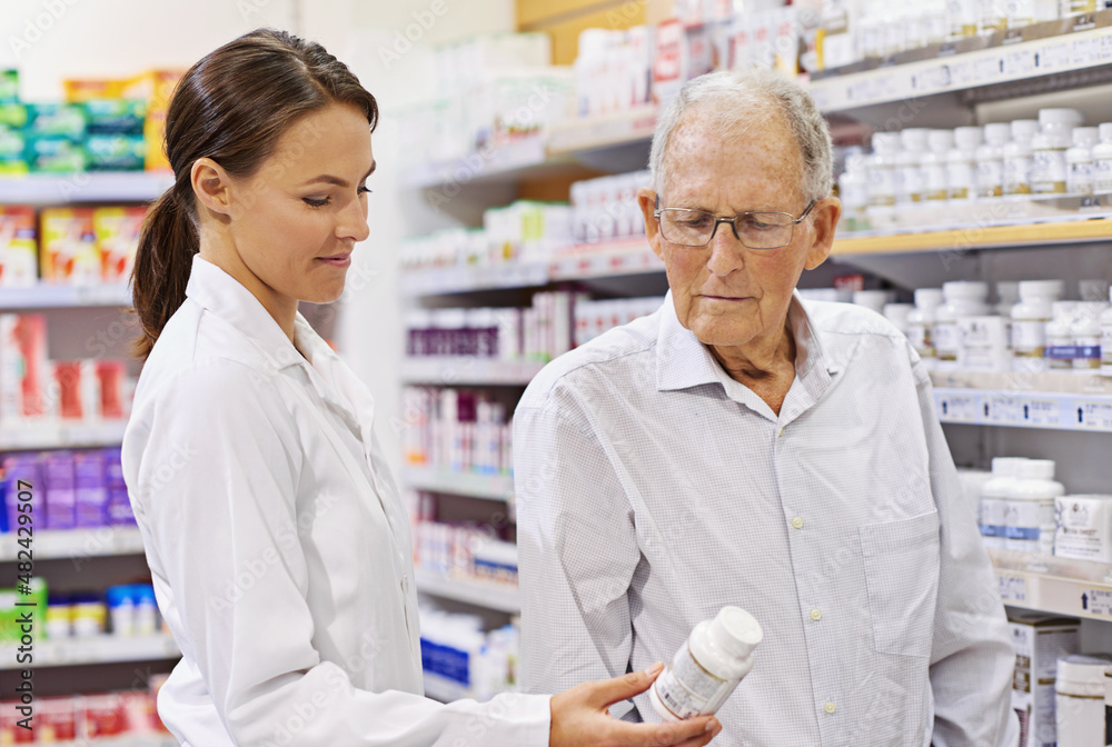 Sharing her wealth of knowledge. Shot of a young pharmacist helping an elderly customer.